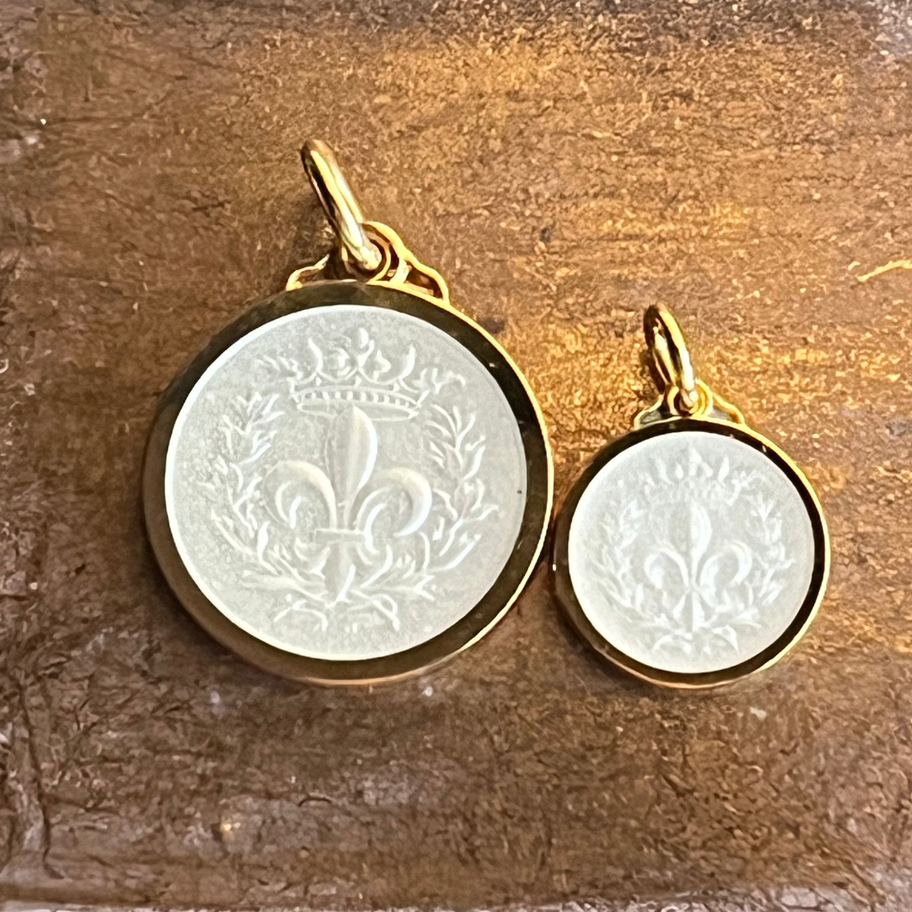 White cream enamel over a fleur de lis on 2 different size necklace pendants