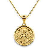 Gold pendant on a gold bead chain displaying the Chi and Rho letters accompanied by the alpha and omega letters.  The round pendant design is bordered by leaves on stems around the perimeter.