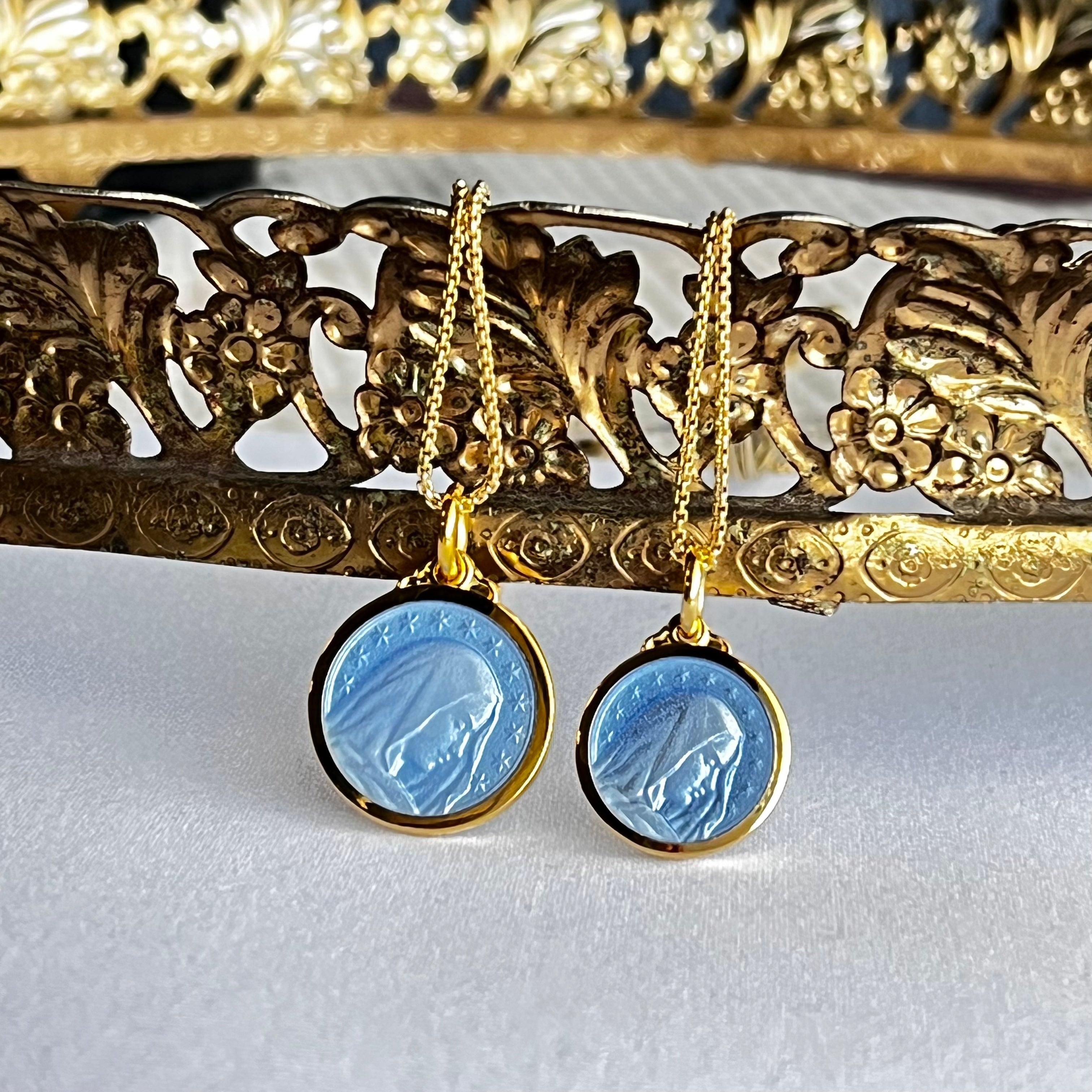 Beautiful side profile of the Blessed Virgin Mary covered in French Blue translucent enamel all in a 14k gold vermeil pendant