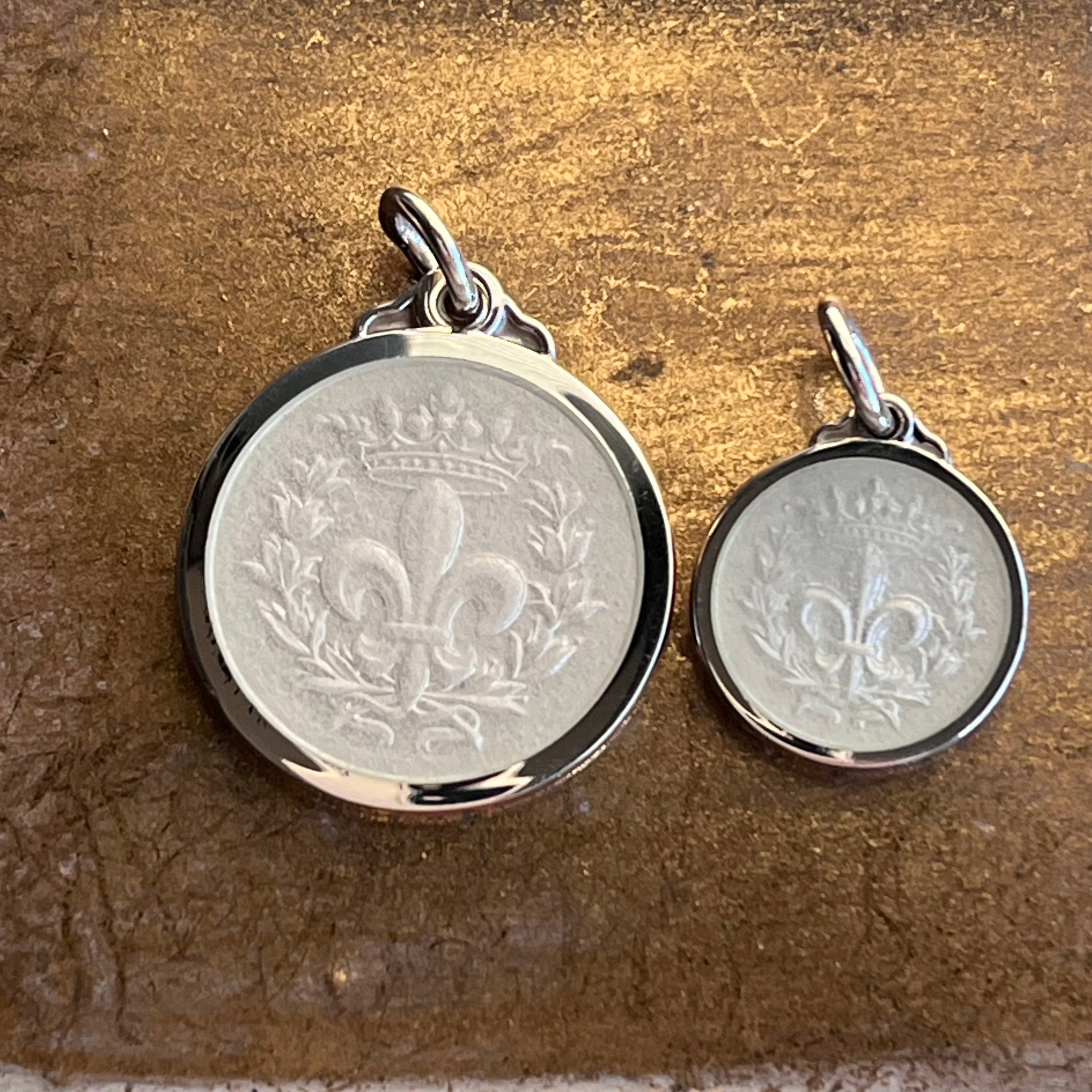 Two sizes of Fleur-de-Lis necklace pendants made from sterling silver and white cream enamel
