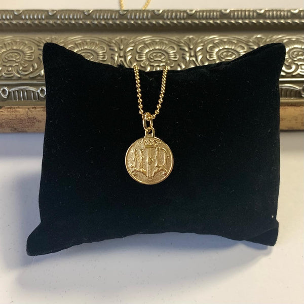 Gold necklace pendant featuring Notre Dame insignia