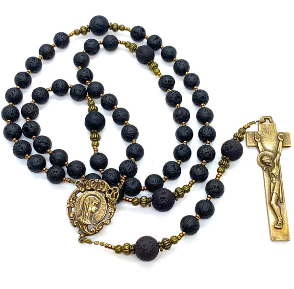 Rosary made from lava rock beads and bronze center and crucifix.  The center features a profile of Mary and the crucifix is the penal crucifix.