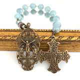 Beautiful Rosary with angels kneeling crucifix and sacred heart of Jesus cross and aquamarine beads in background