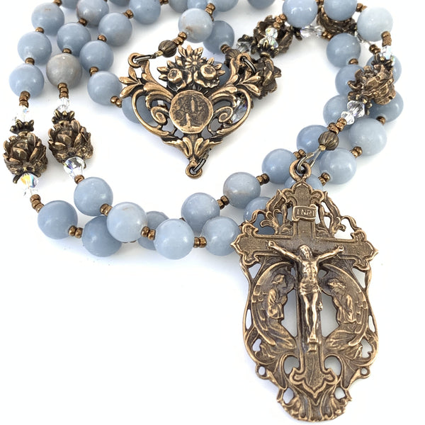 Five decade rosary featuring angelstone rosary beads, an open scroll angels kneeling crucifix and Lourdes center medal.