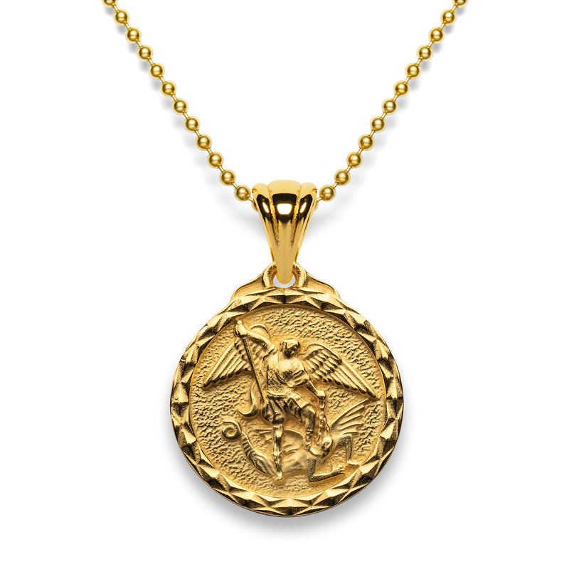 A round gold vermeil pendant hanging on a gold chain showing St Michael, wings and all, with his sword poised to strike holding a demon down with his foot.