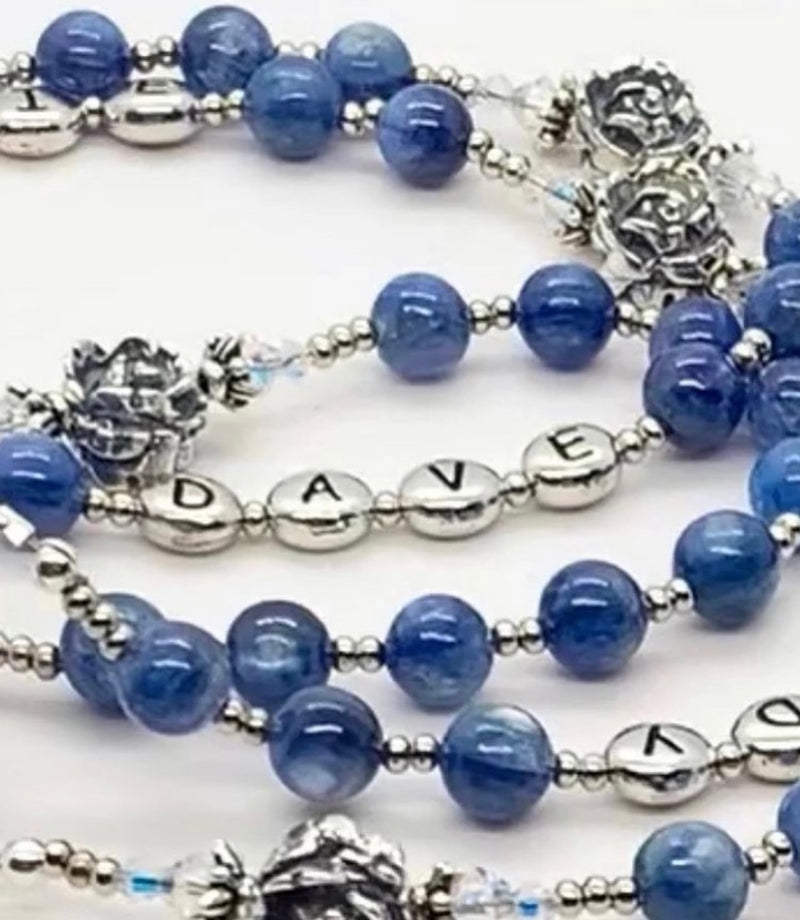 A one of a kind custom rosary for weddings featuring the names of the bride and groom.  Picture shows blue hail Mary beads and sterling silver names.