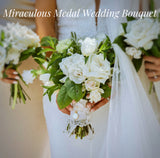 White flower wedding bouquet showing a white miraculous medal