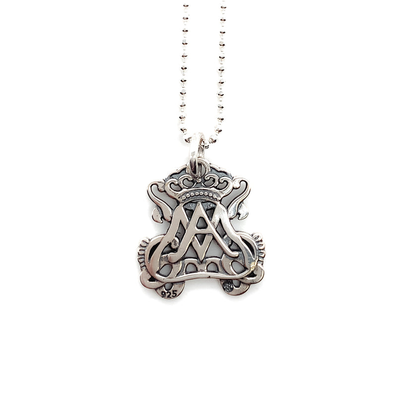 Small sterling silver openwork auspice maria pendant for a necklace shown hanging from a silver bead chain.